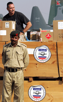 A Pakistani solider (front) stands guard next to the relief goods sent by United States Agency for International Development (USAID) at a military base in Rawalpindi October 15, 2005. Pakistan raised the official death toll from the Kashmir earthquake to 38,000 a week after one of the most devastating quakes to hit South Asia in recorded history. REUTERS/Mian Khursheed