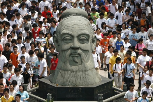 Chinese students walk past a statue of Confucius in Wuhan, in central China’s Hubei province, on June 7, 2007.