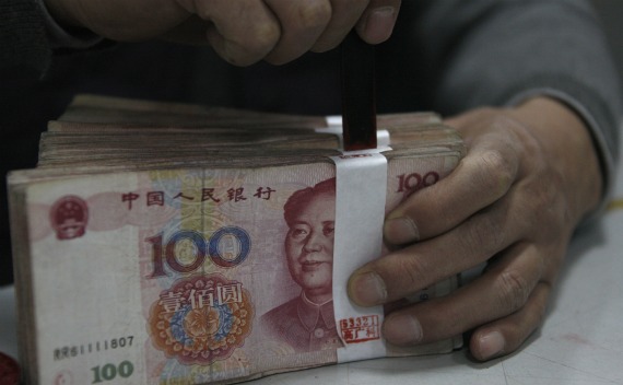 An employee seals a stack of yuan banknotes at a branch of Industrial and Commercial Bank of China in Huaibei, Anhui province on April 6, 2011. 