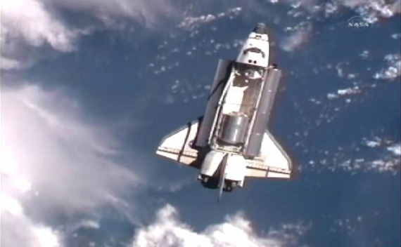 The space shuttle Atlantis is seen with earth in the background as it draws near the International Space Station for docking (Courtesy Reuters).