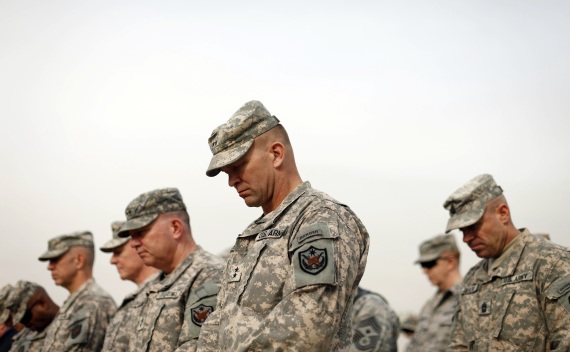 U.S. military personnel lower their heads during the ceremony of the encasing of the U.S. Forces in Iraq colors in Baghdad on December 15, 2011 (Courtesy Reuters/Pool).