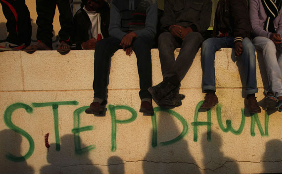 Protesters sits atop a wall during anti-Qaddafi demonstrations on March 14, 2011.