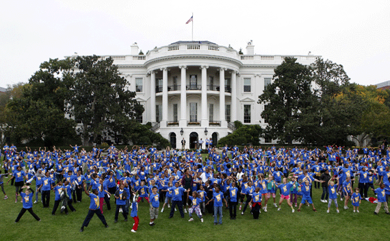 U.S. first lady Michelle Obama (C) jumps with four hundred children at an event on the South Lawn of the White House in Washington October 11, 2011 to launch a challenge to help break the Guinness World Records title for the most people doing jumping jacks in a 24-hour period. To break the record, more than 20,000 people from around the world must perform jumping jacks for one minute. REUTERS/Yuri Gripas 