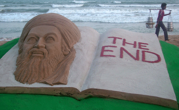 A vendor walks past a sand sculpture of Al Qaeda leader Osama bin Laden created by Indian sand artist Sudarshan Patnaik on a beach in Puri in the eastern Indian state of Orissa May 2, 2011