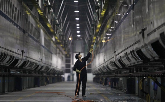 An employee hoses a China Railway High-speed Harmony bullet train at the high-speed train maintenance base in Wuhan, Hubei province on October 19, 2011.