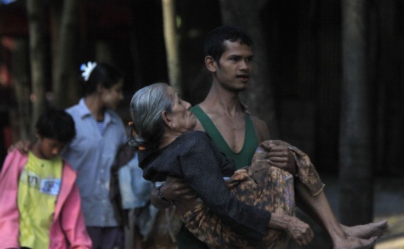 A Myanmar refugee, who crossed over from Myanmar to Thailand when a battle erupted between Myanmar’s soldiers and rebels, carries his relative at the Thai border town of Mae Sot on November 8, 2010.