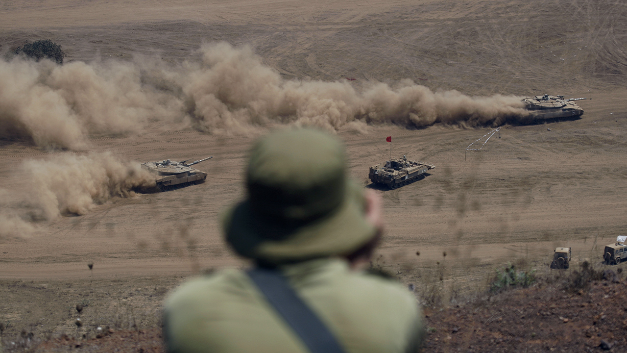 Israeli soldier watches as Israeli tanks manoeuvre during military drill near Ein Zivan in Golan Heights.