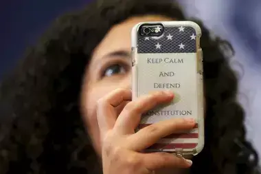 An audience member holds up a phone with a case reading "Keep Calm and Defend the Constitution" during a "Get Out to Caucus" rally with U.S. Democratic presidential candidate Hillary Clinton in Cedar Rapids