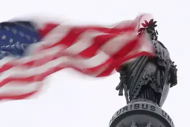 The U.S. flag flies near the Statue of Freedom atop the U.S. Capitol in Washington, DC.
