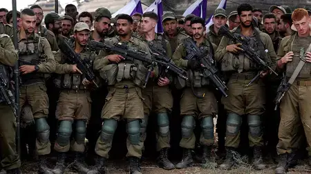 Israeli soldiers lined up in a field near the border with the Gaza Strip.