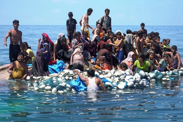 Rohingya refugees stand on a capsized boat before being rescued in the waters of West Aceh, Indonesia on March 21, 2024.