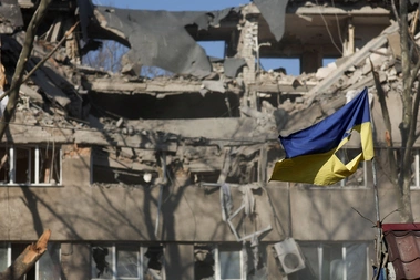 A Ukrainian flag waves in front of a damaged building hit in a military strike, as Russia's invasion of Ukraine continues, in Mykolaiv, Ukraine, March 21, 2022