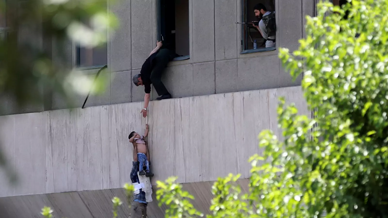A boy is evacuated from the Iranian parliament during an attack.