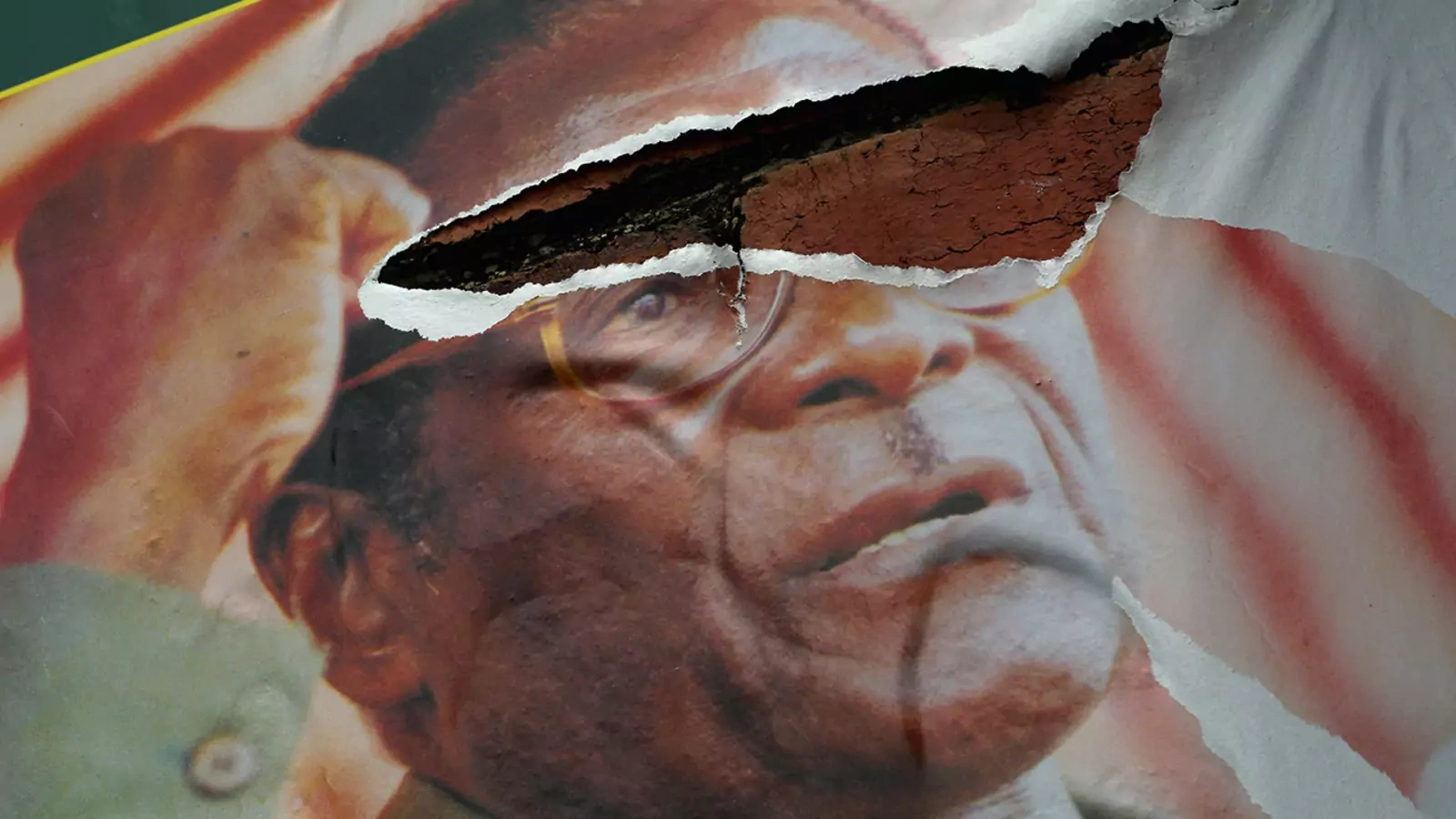 A poster of President Robert Mugabe hangs torn on a streetside wall in Bulawayo, Zimbabwe.
