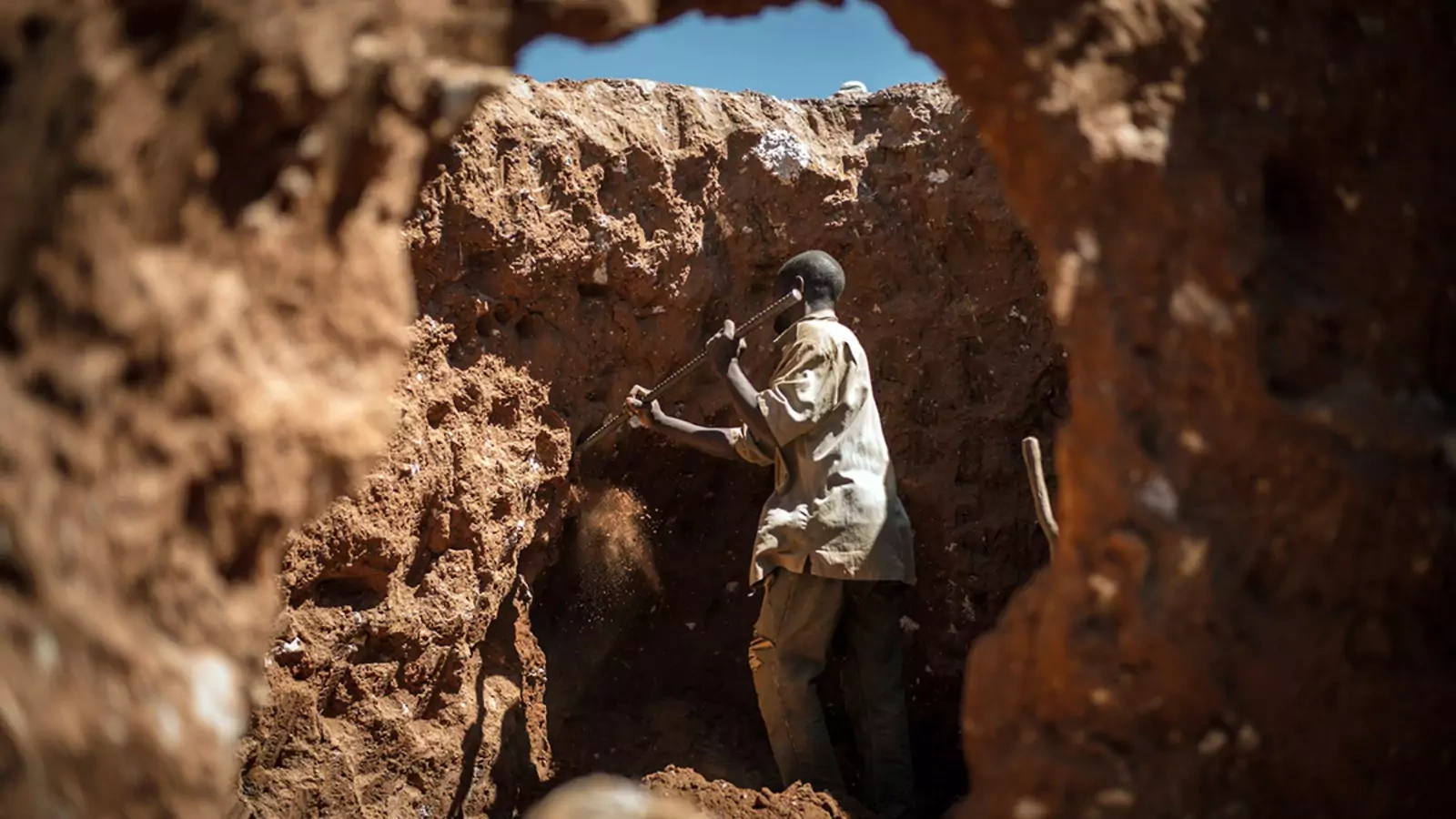A man digs through some mine waste searching for leftover cobalt.