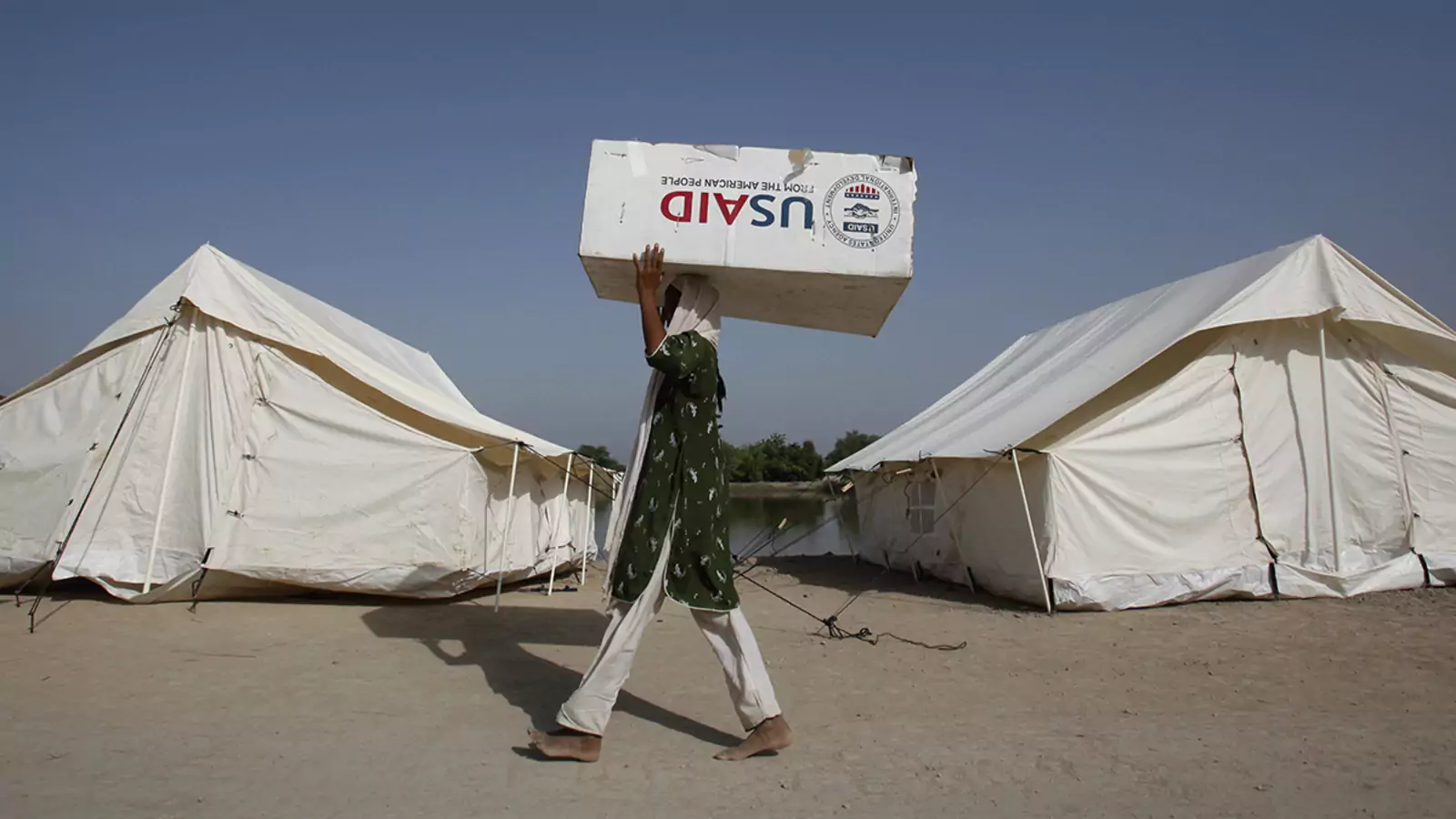 A woman displaced by floods uses a box from the U.S. Agency for International Development, the U.S. government's main foreign aid agency, to move her belongings in Dadu, Pakistan, in 2010.