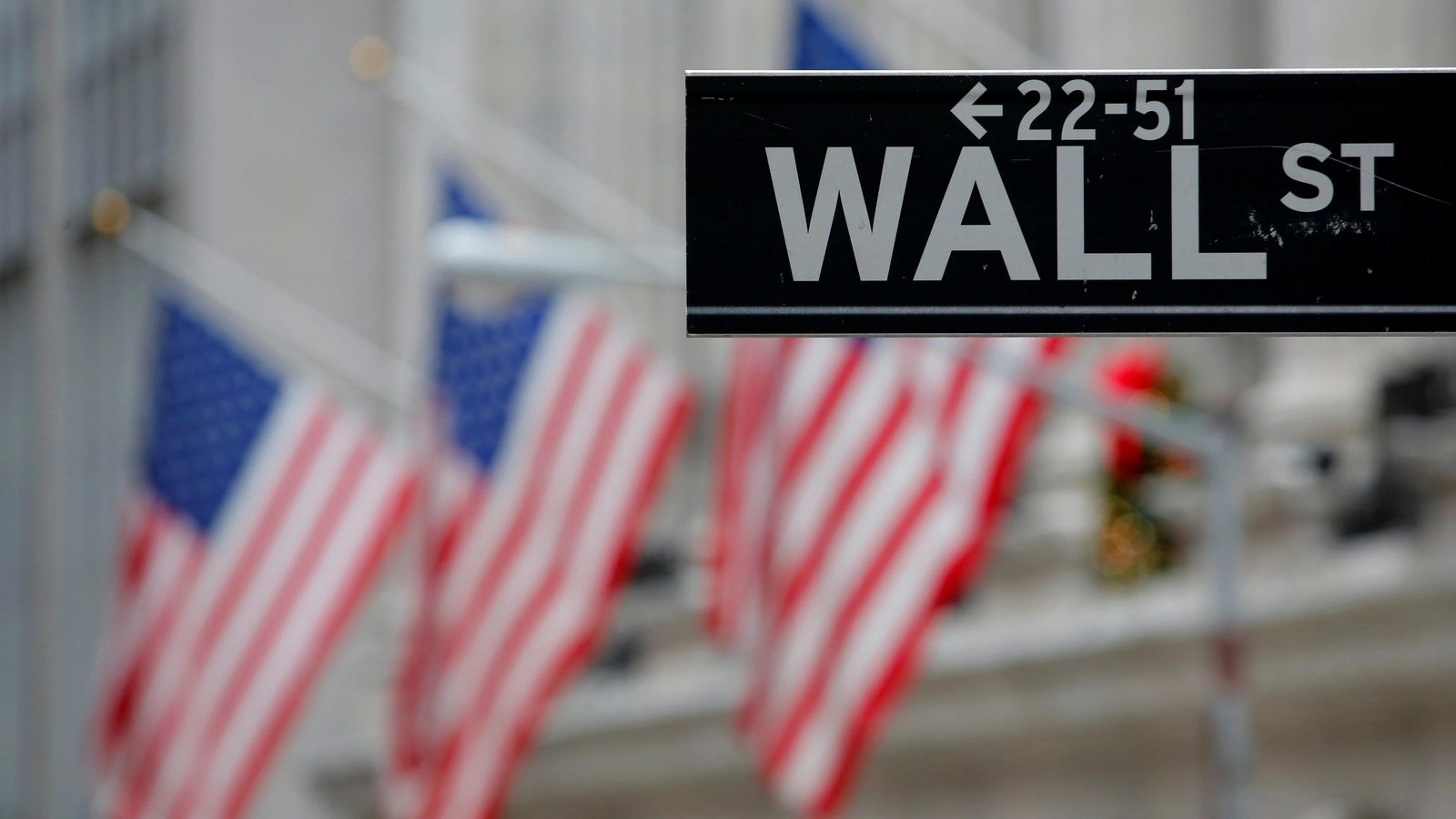 A street sign for Wall Street is seen outside the New York Stock Exchange (NYSE) in Manhattan, New York City.