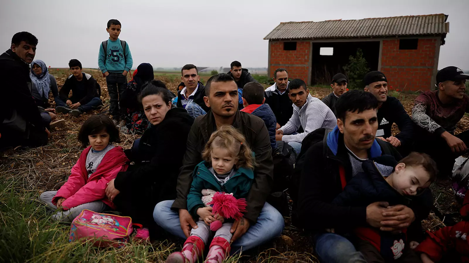Syrian refugees who crossed the Evros River wait to be transferred by police to a first reception center in Greece.