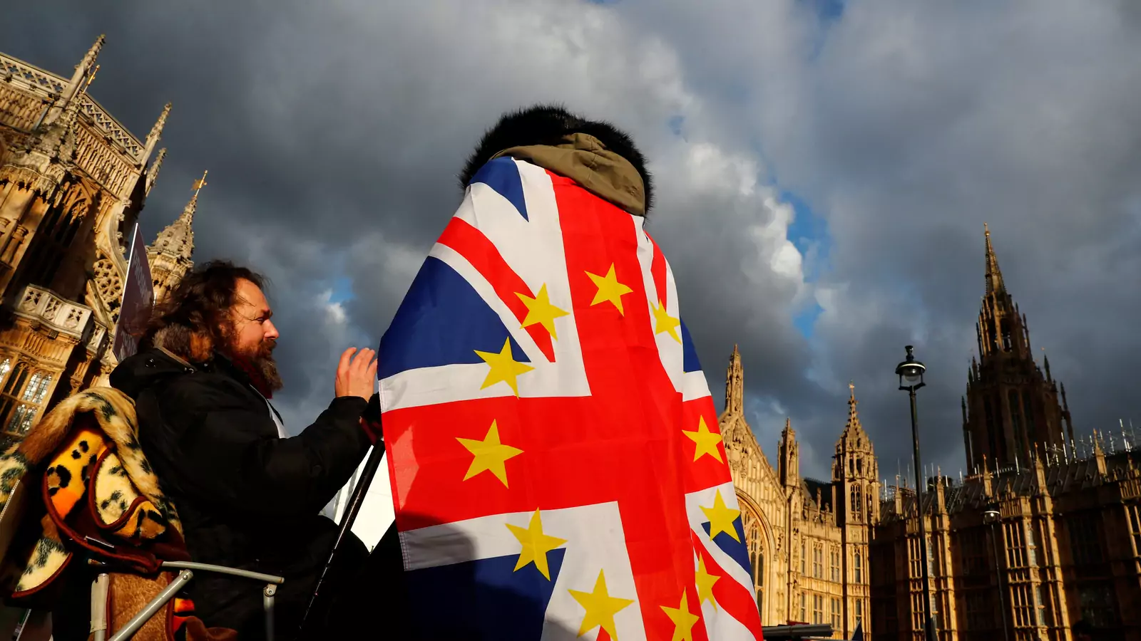 An anti-Brexit demonstrator wears a Union flag decorated with the stars of the EU flag opposite the Houses of Parliament in London, Britain.