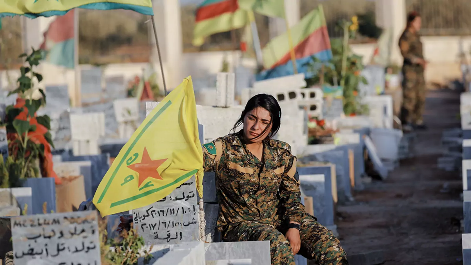 Fighters of the Syrian Democratic Forces visit the graves of their late comrades at a cemetery in Kobani, Syria.