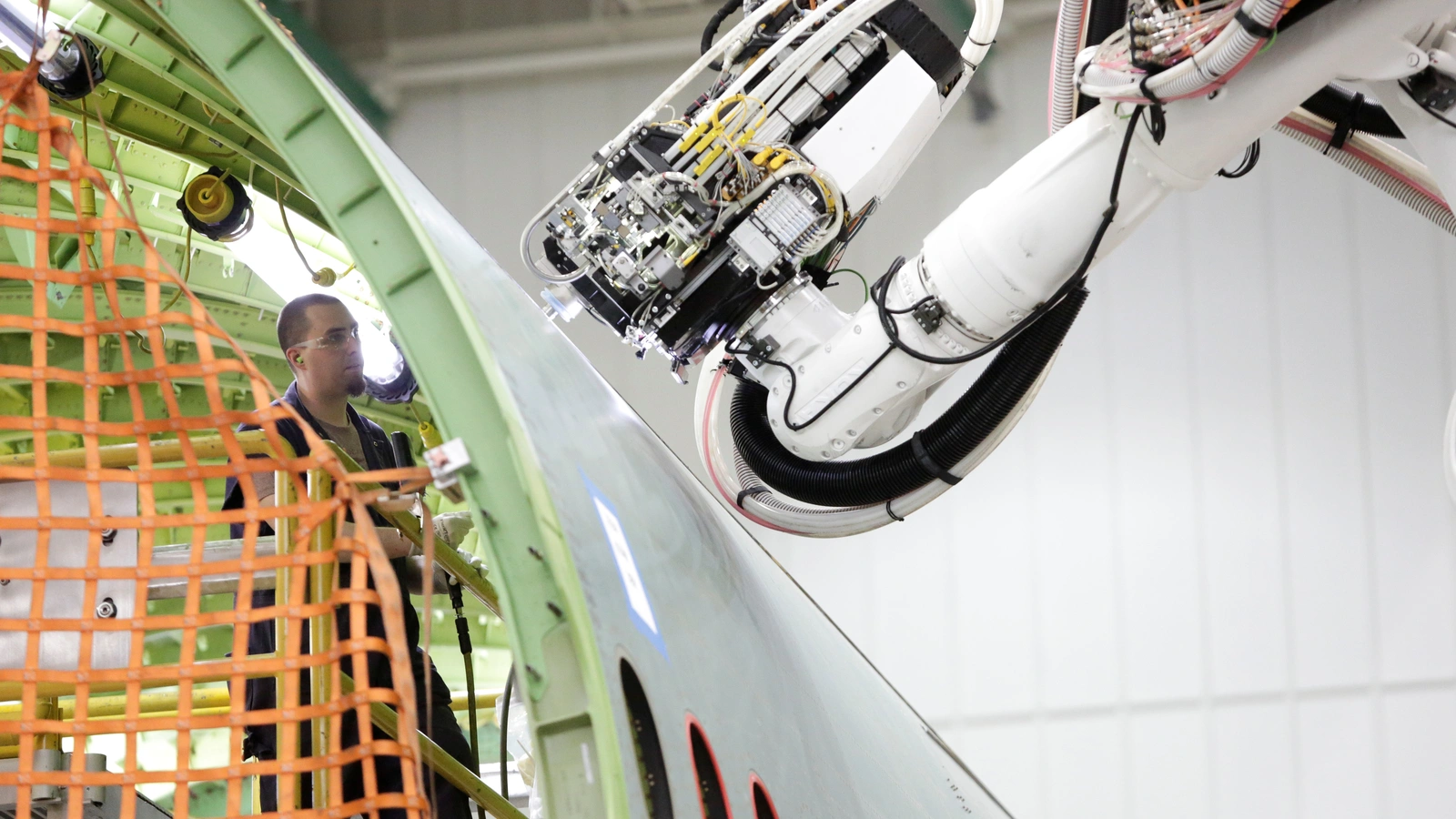 A worker (L) stands inside a 777 fuselage as a machine works on the outside at the Fuselage Automated Upright Build (FAUB) and mid bodies area at Boeing's production facility in Everett, Washington, U.S. June 1, 2017.