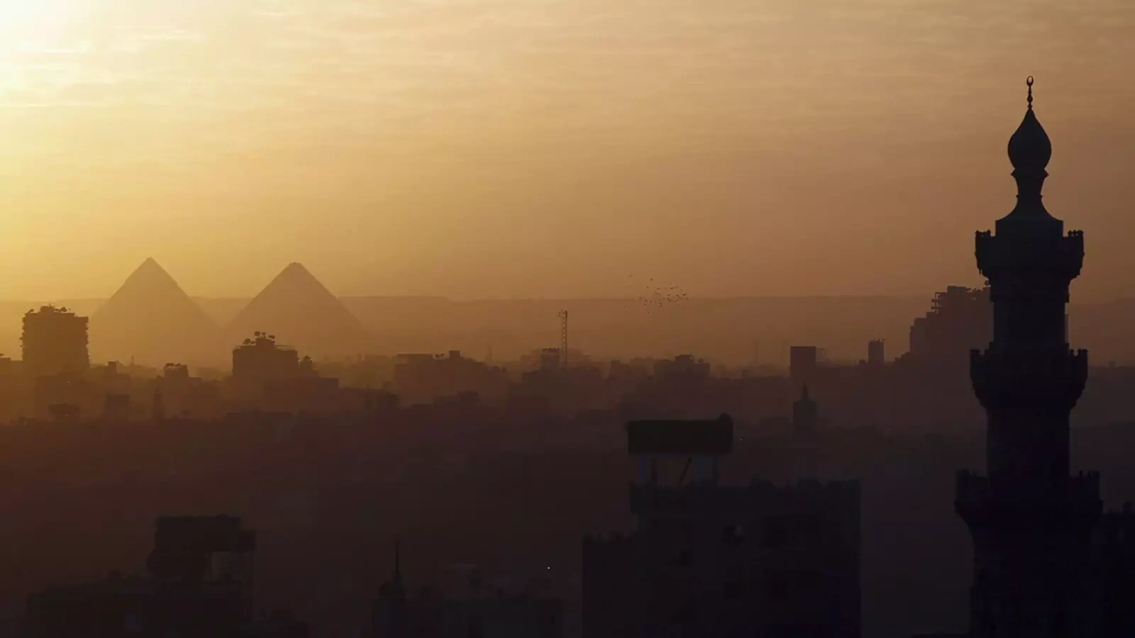 A view of mosques and the great pyramids before sunset in Cairo.