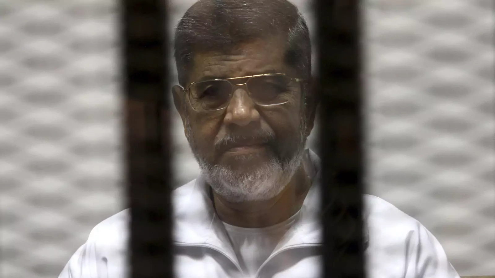 Ousted Egyptian President Mohamed Mursi is seen behind bars during his trial at a court in Cairo May 8, 2014. 