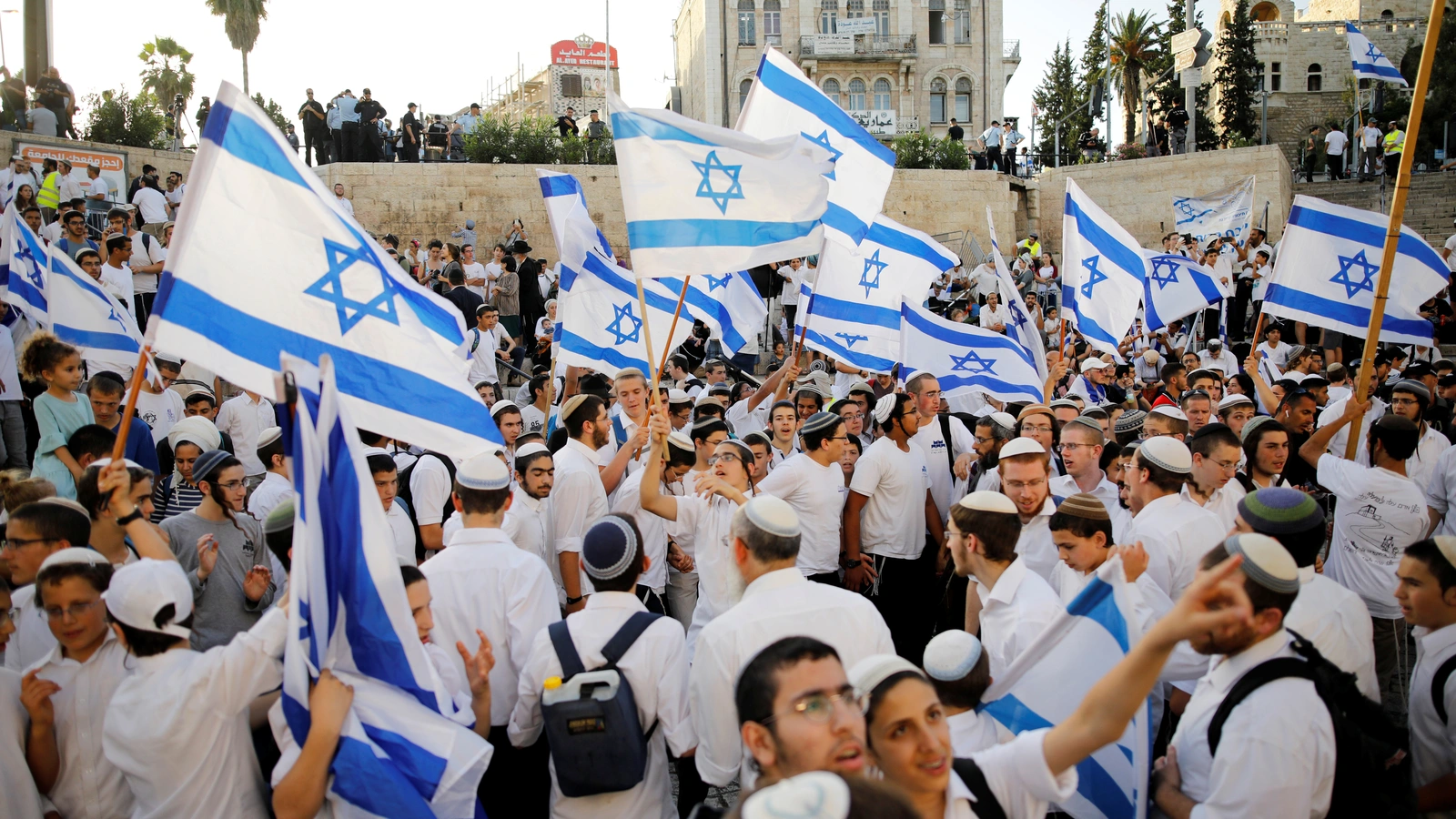 Jewish youth wave Israeli flags as they participate in a march marking "Jerusalem Day", near Damascus Gate in Jerusalem's Old City June 2, 2019.