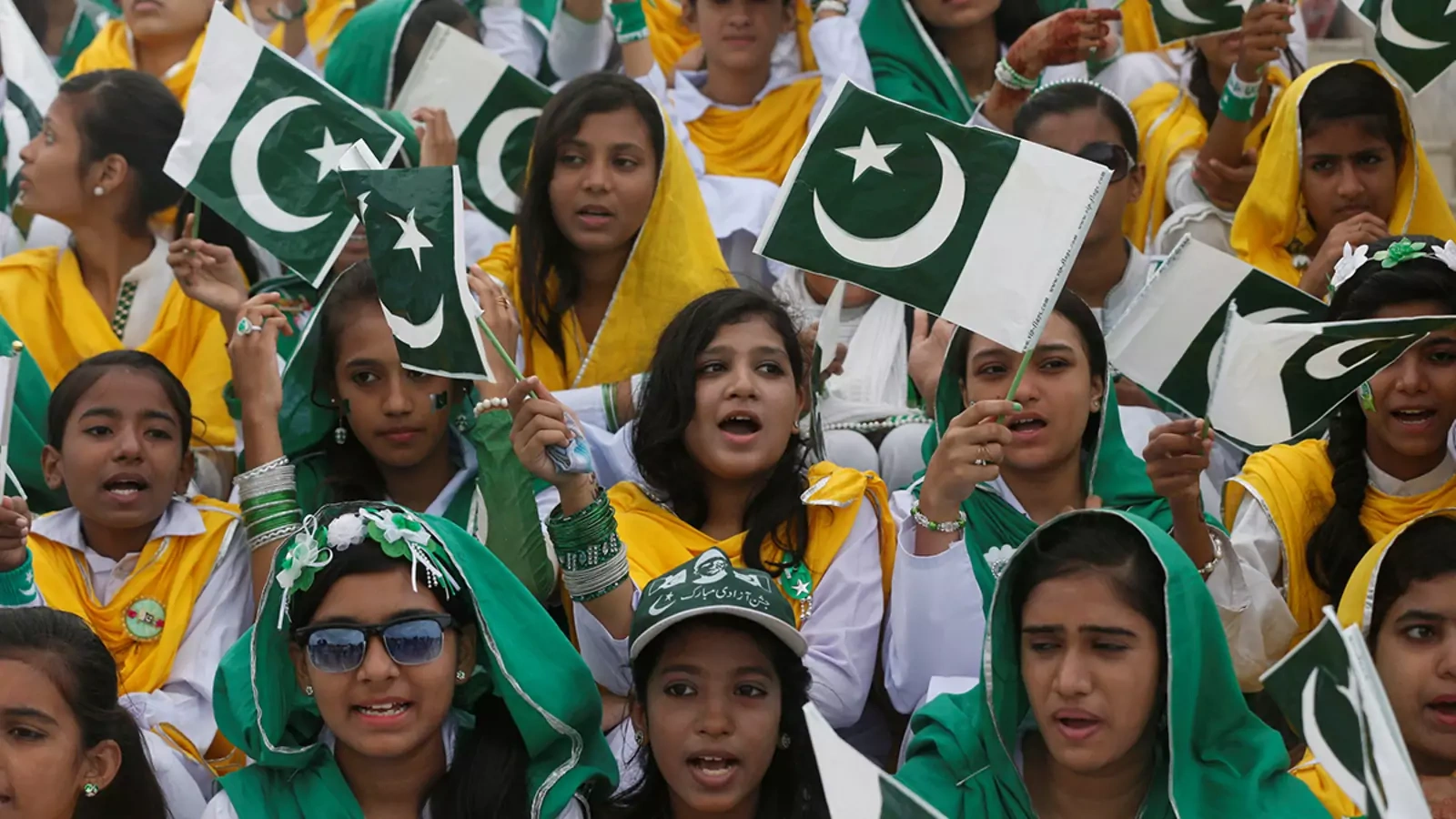 Attendees wave Pakistan’s national flag at a ceremony to celebrate the country's seventieth independence day in Karachi.