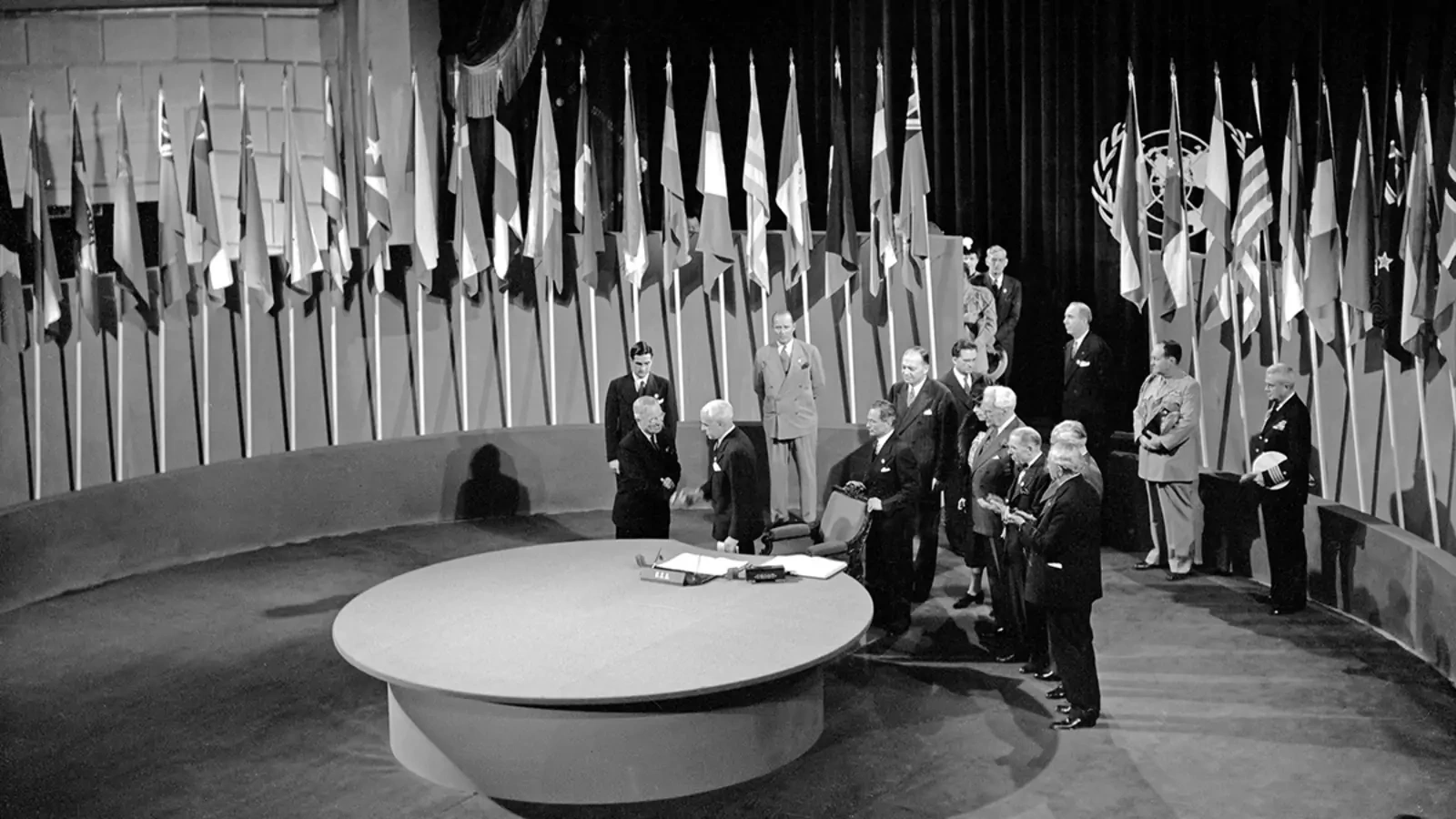 U.S. President Harry S. Truman and Secretary of State Edward R. Stettinius, Jr., shake hands at the signing of the United Nations Charter in 1945.