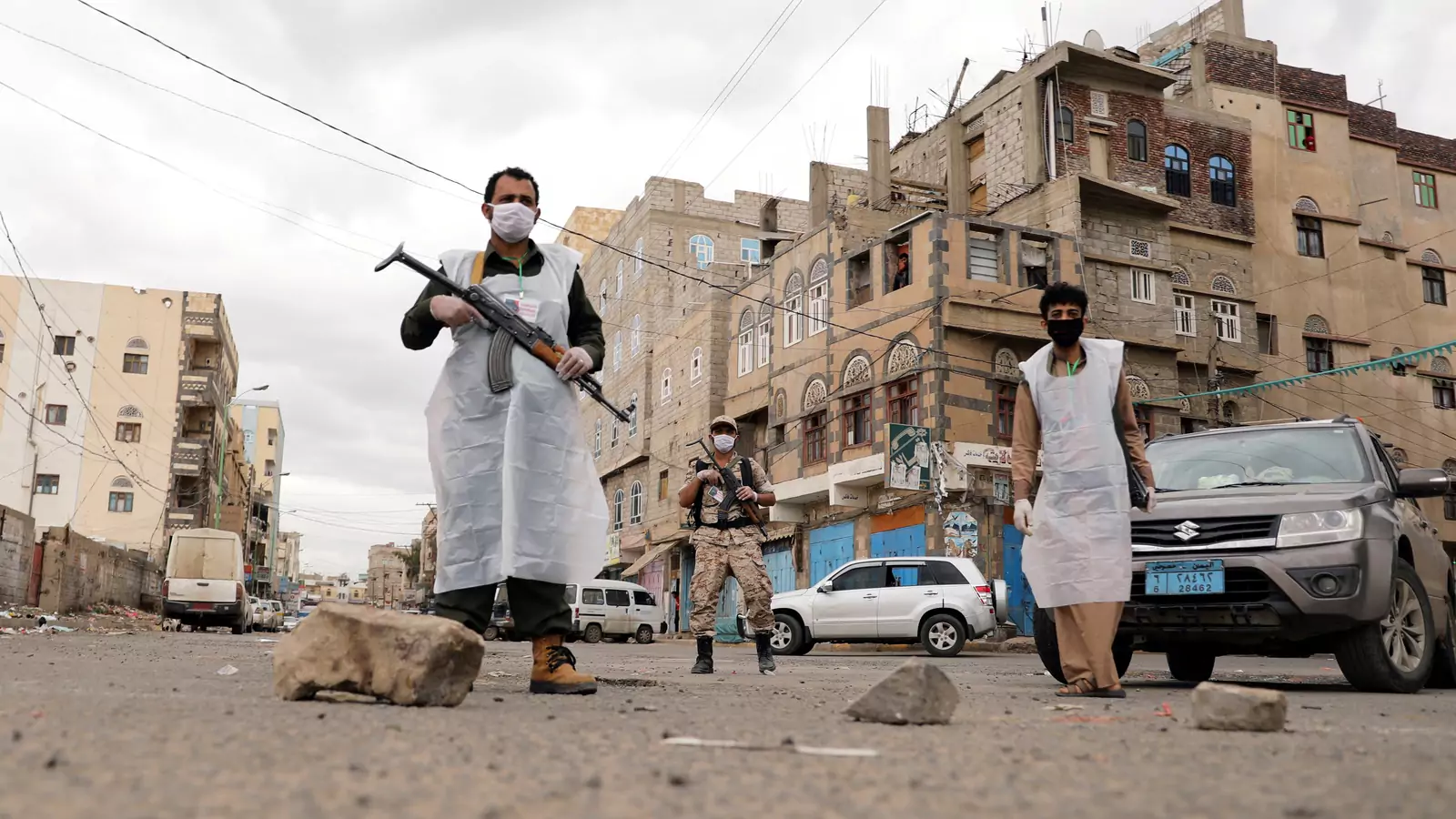 Security men wearing protective masks stand on a street during a twenty-four hour curfew that was instituted over concerns about the spread of the novel coronavirus in Sanaa, Yemen, on May 6, 2020.