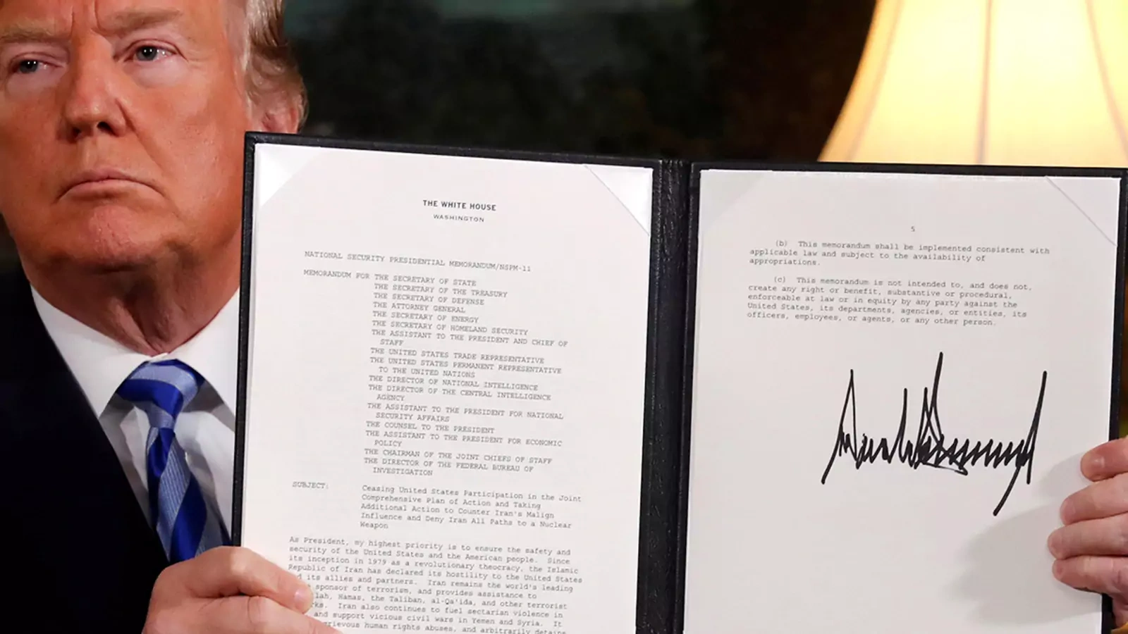 President Trump holds up a proclamation declaring his intention to withdraw from the Iran nuclear deal.