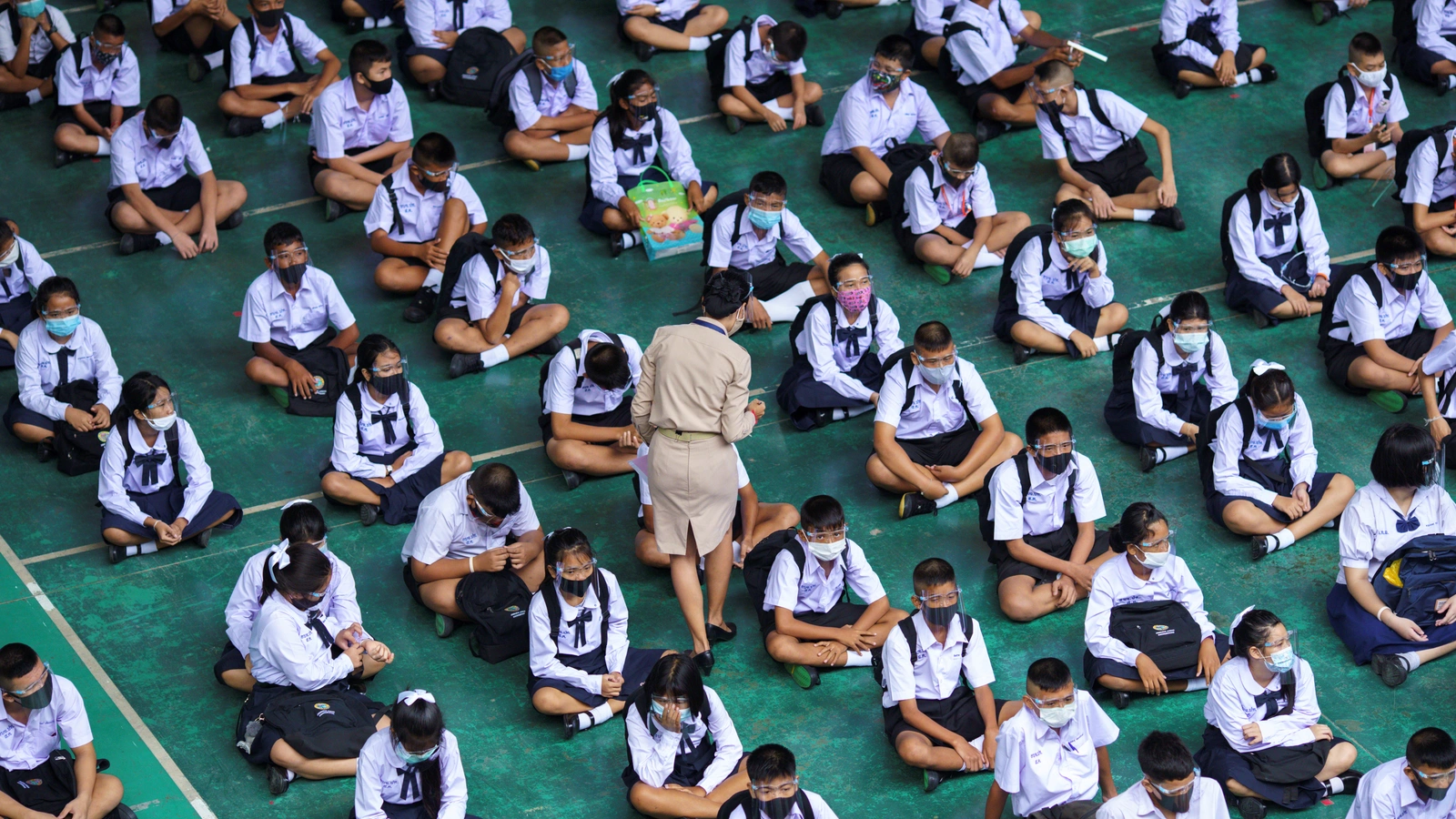 Students wearing face masks and face shields sit as they attend a flag-raising ceremony as schools nationwide reopened, in Pathum Thani province, Thailand on July 1, 2020.