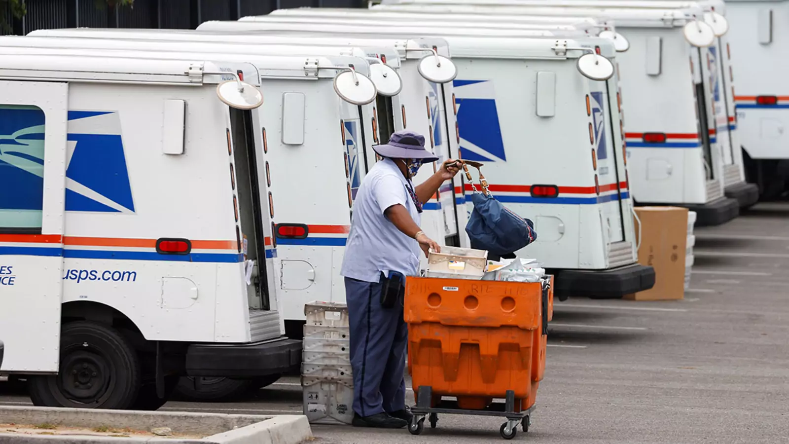A U.S. postal worker loads his truck as he begins his day during the outbreak of COVID-19 in Carlsbad, California.