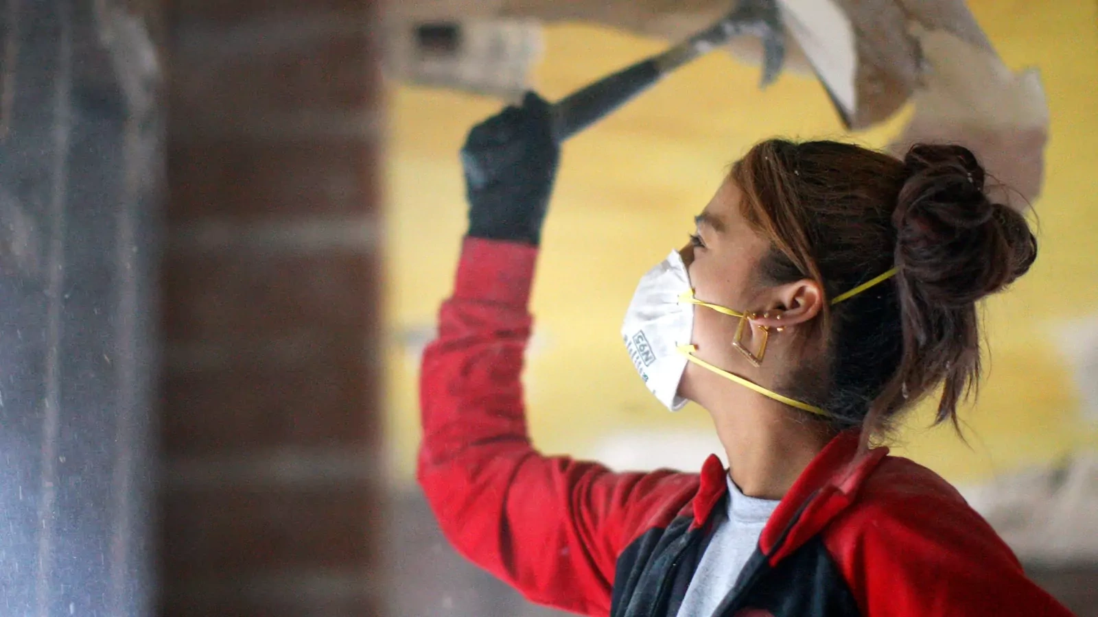 An AmeriCorps worker helps gut a house being renovated for affordable housing.