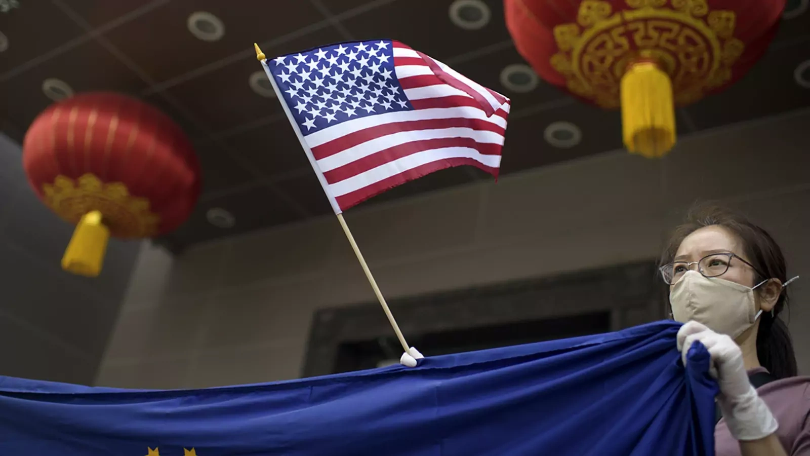 A protester holds a U.S. flag outside of the Chinese consulate in Houston after the U.S. State Department ordered China to close the consulate.