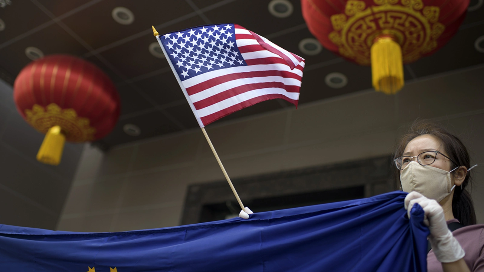 A protester holds a U.S. flag outside of the Chinese consulate in Houston after the U.S. State Department ordered China to close the consulate.