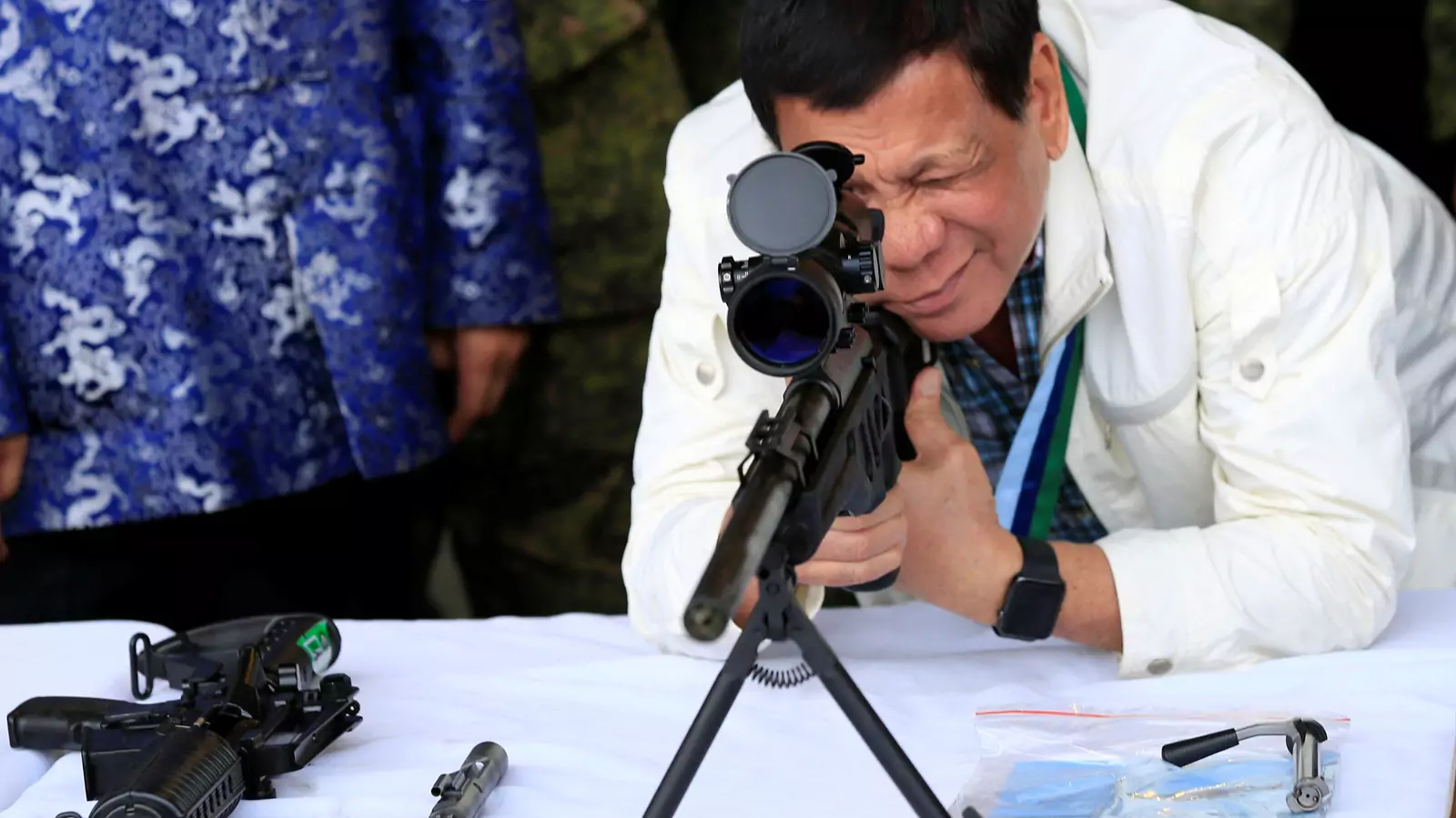Philippine President Rodrigo Duterte checks the scope of a 7.62mm sniper rifle during the turnover ceremony of China's urgent military assistance given "gratis" to the Philippines, at Clark Air Base, near Angeles City, Philippines, on June 28, 2017. 