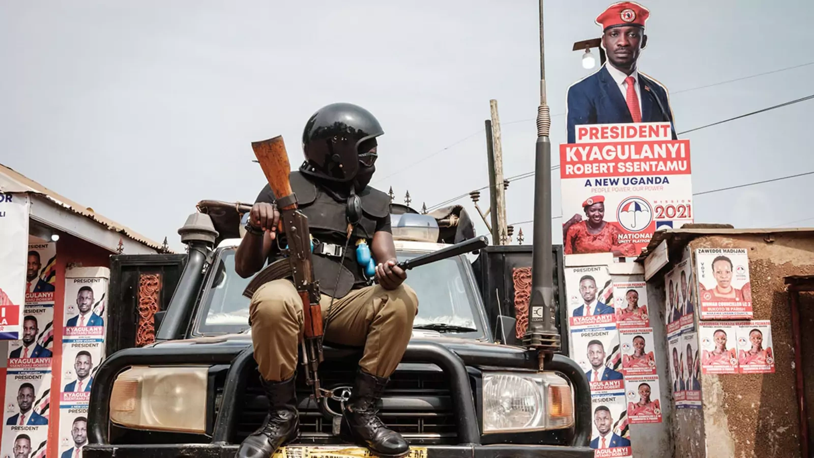 A police officer sits on a car at the headquarters of the National Unity Platform in Kampala, Uganda, in January 2021.