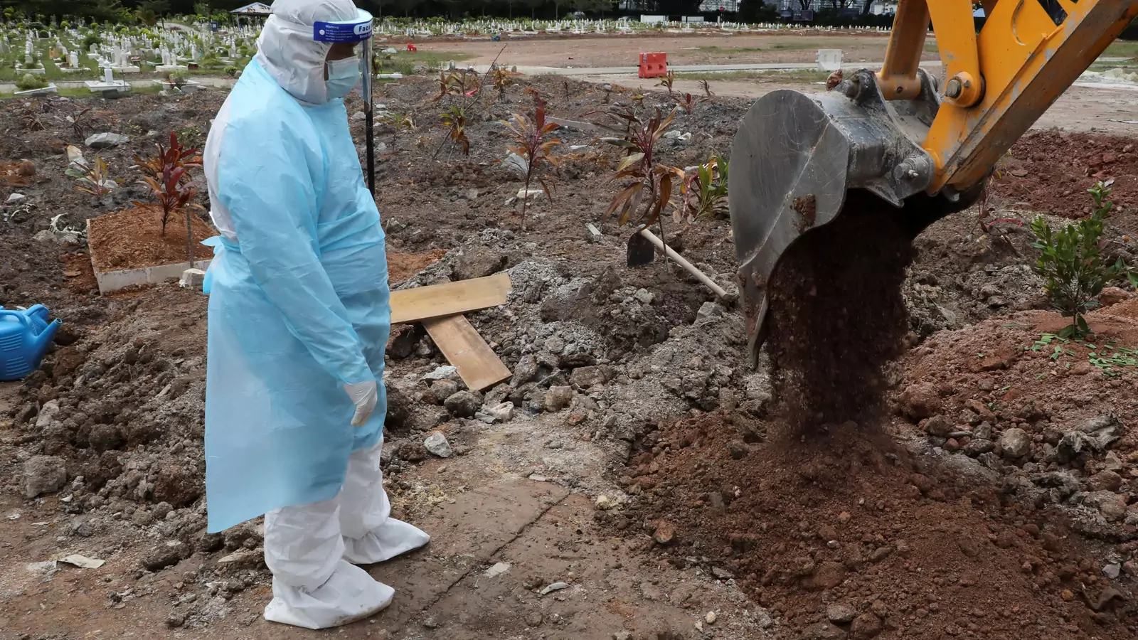 A cemetery worker wearing a protective suit helps to bury a victim of the coronavirus disease (COVID-19) at a cemetery in Shah Alam, Malaysia, on July 14, 2021.