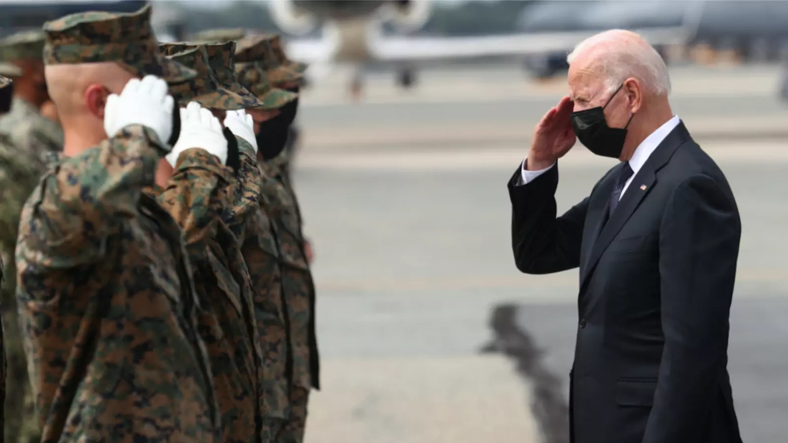 President Joe Biden salutes members of the U.S. Marine Corps Honor Guard. 