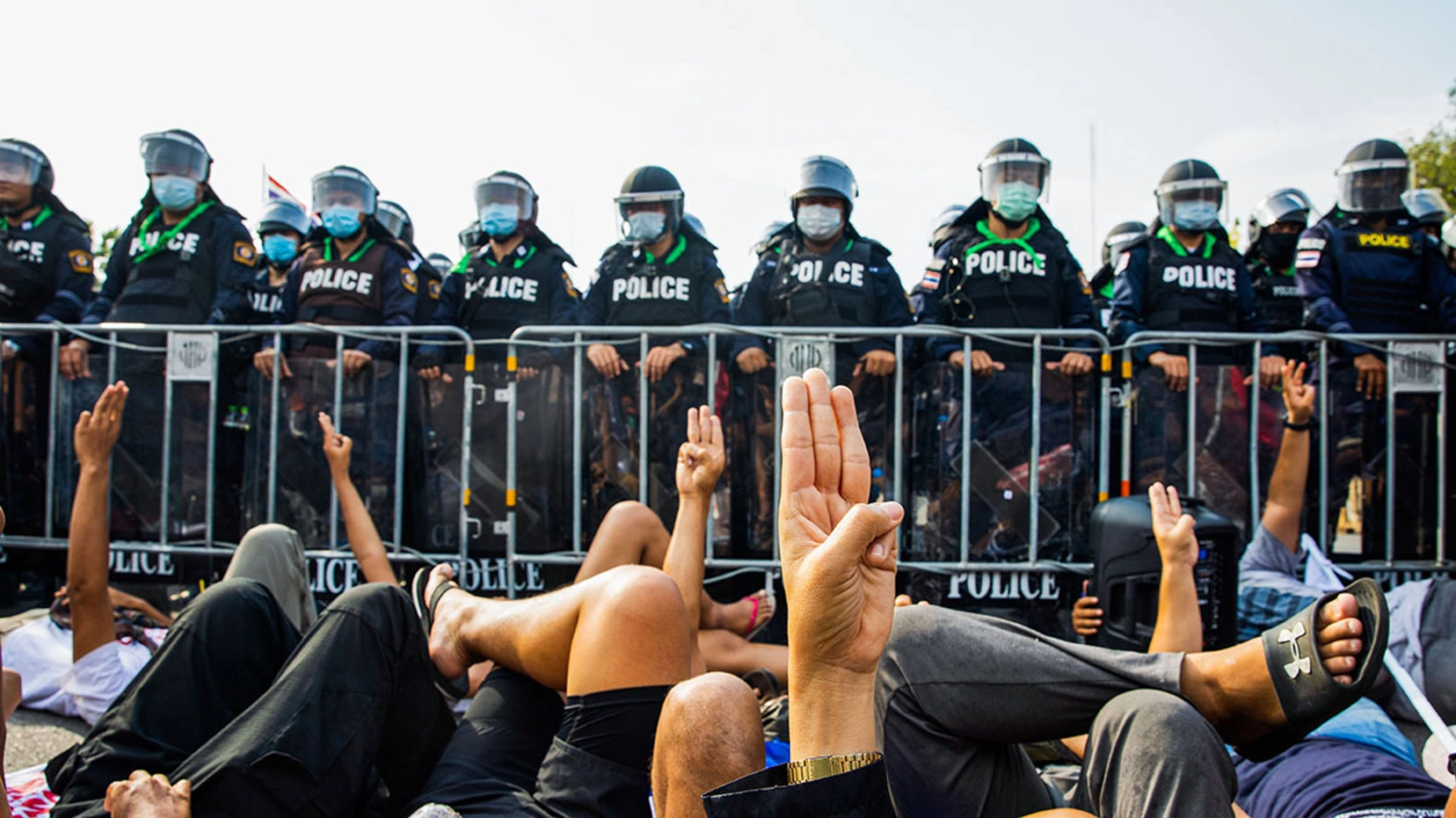 Pro-democracy protesters in Thailand raise their hands in a three-finger salute.