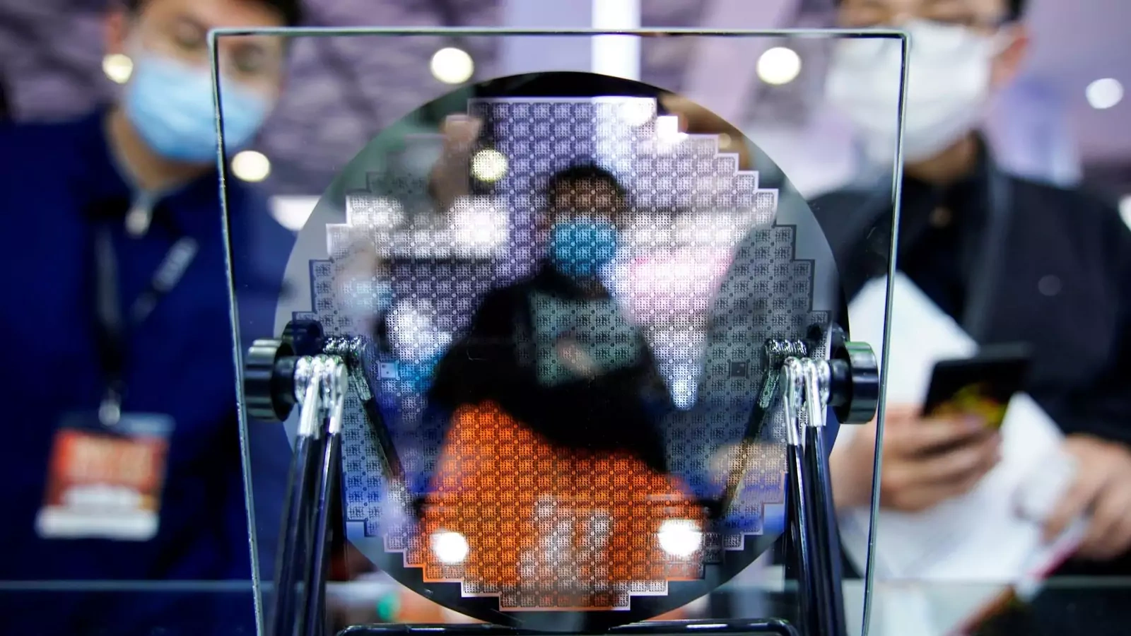 Visitors look at a display of a semiconductor device at Semicon China, a trade fair for semiconductor technology, in Shanghai, China.