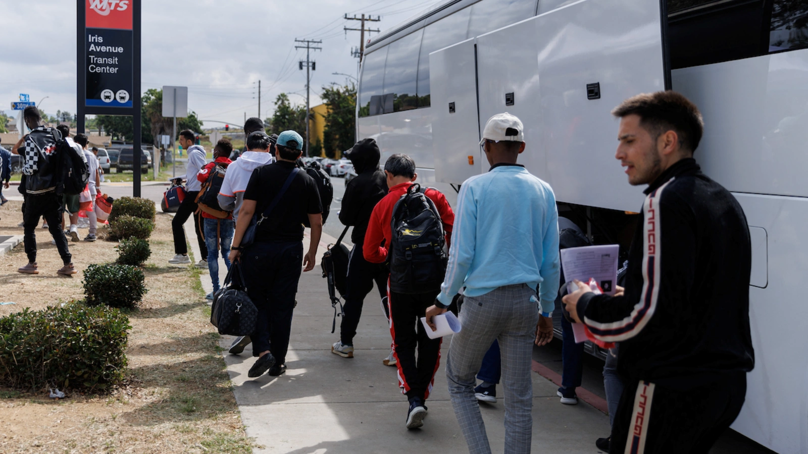 After processing by U.S. Immigration, migrants are dropped off by a bus at a transit center to continue their journey in the United States from San Diego, California.