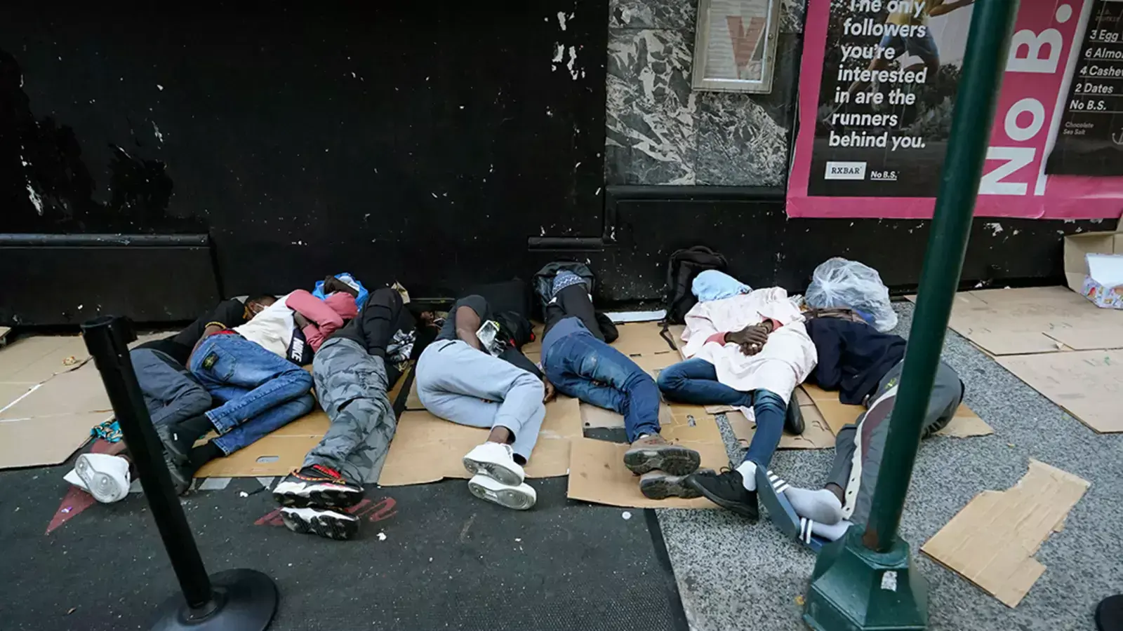 Migrants sleep outside the Roosevelt Hotel in New York as they wait for housing.