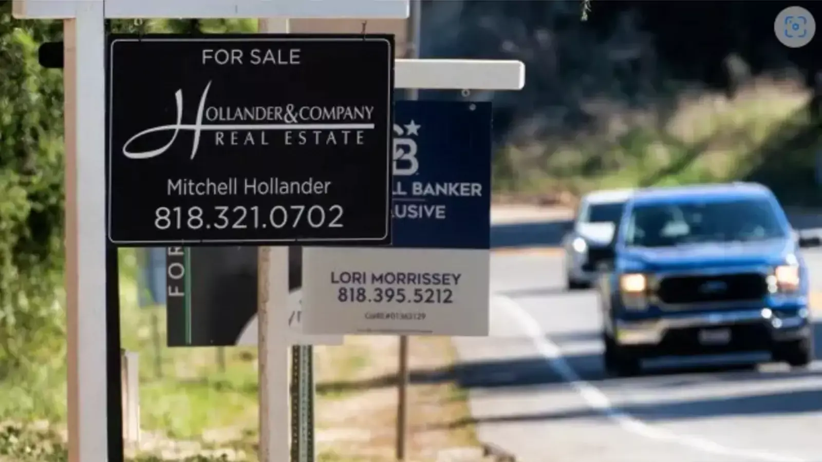 Home sale signs are posted along Topanga Canyon road in Los Angeles on Oct. 19, 2023.