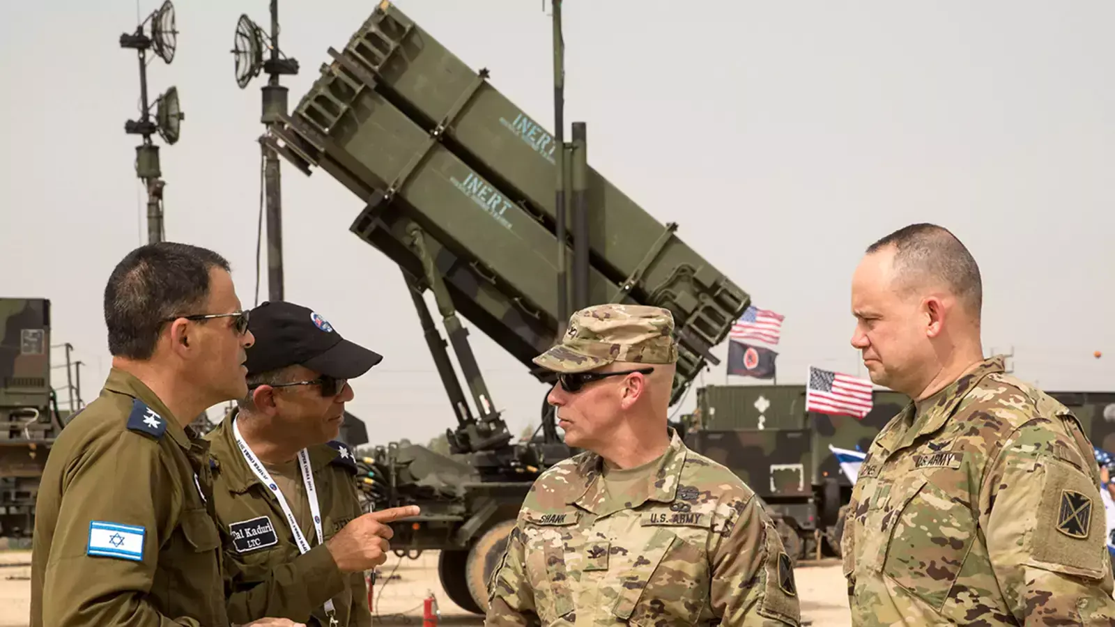 U.S. and Israeli army officers talk in front a US Patriot missile defense system.