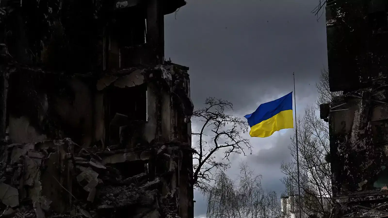 The Ukrainian flag flutters amid buildings destroyed in Russia’s bombardment of the Ukrainian town of Borodianka.
