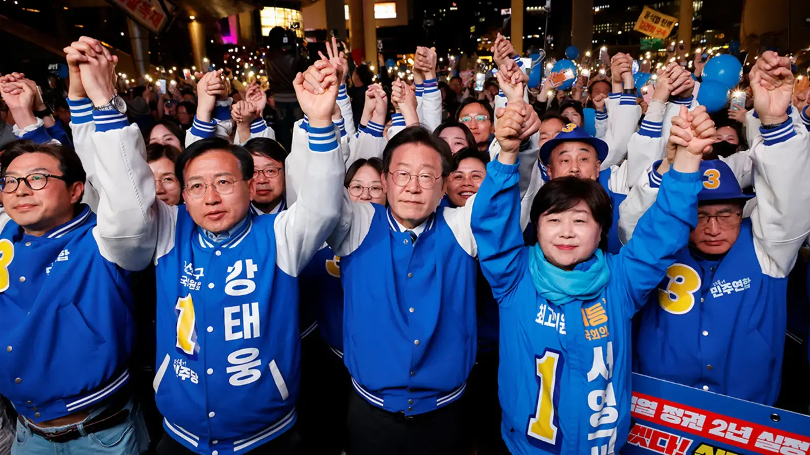 Lee Jae-myung (middle), leader of the main opposition Democratic Party, stands with supporters at a campaign rally in Seoul, South Korea on April 9, 2024.