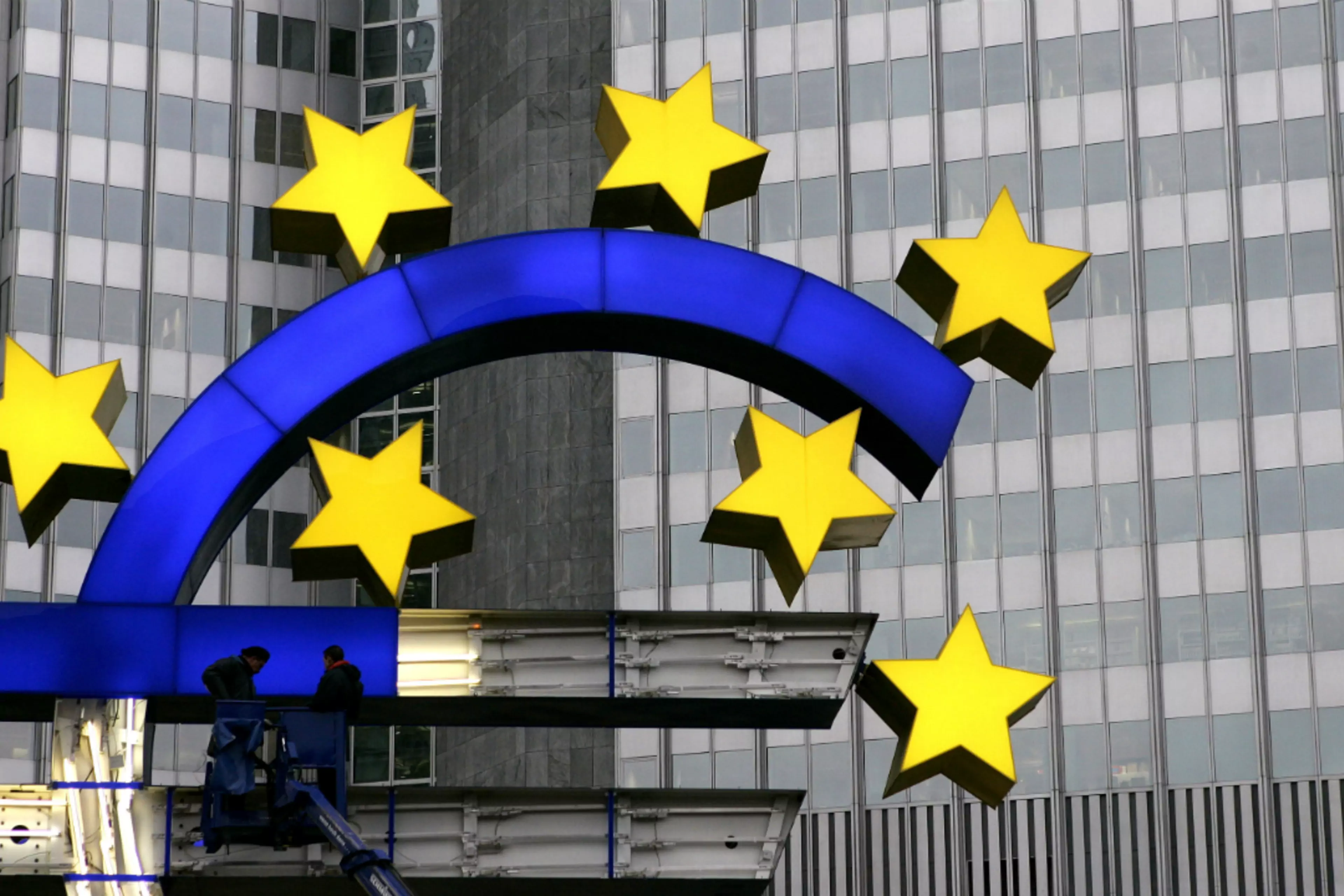 Workers repair the euro sign in front of the European Central Bank headquarters in Germany.
